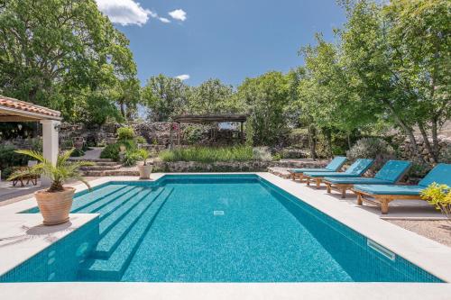 马林斯卡Heritage Villa Laurel的后院的游泳池,带蓝色躺椅