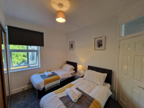 KentSwanley Guest House的一间卧室设有两张床和窗户。