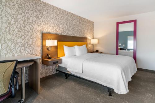 班戈Home2 Suites by Hilton Bangor的酒店客房带一张床铺、一张书桌和一间卧室