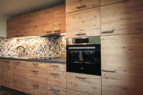 Srednja Vas v BohinjuApartma Gorski razgled的厨房配有木制橱柜和黑烤箱。
