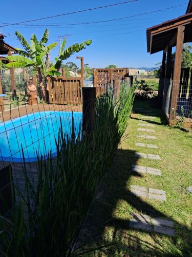 因比图巴Praia do Rosa loft com cozinha的后院设有游泳池和围栏
