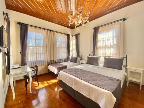 安塔利亚Necip Bey Konağı的卧室配有一张床、一张书桌和窗户。