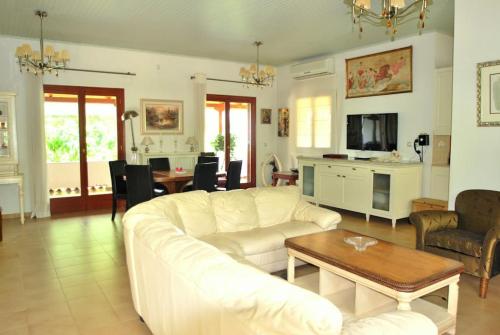 马拉希亚斯Fokiotripa (lovely villa on an enchanting beach)的客厅配有白色的沙发和桌子