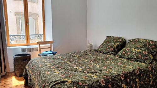 莫尔莱Au Fil de soi的一间卧室配有一张带绿色棉被的床和窗户。