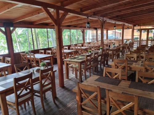 鲁恰内尼达Ośrodek Wypoczynek Wodnik的一间空餐厅,配有木桌和椅子