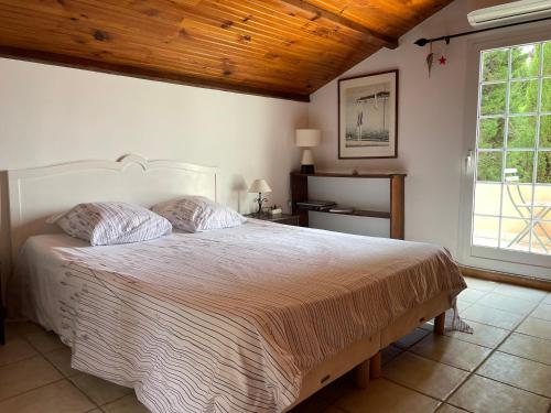尼斯Chambre d'hôtes en duplex du petit mas niçois的一间卧室设有一张带木制天花板的大床