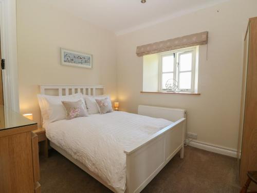 伯福德Ewecub Barn的卧室配有白色的床和窗户。