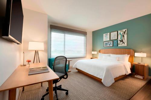 达拉斯Element Dallas Love Field的酒店客房配有一张床、一张书桌和一台电脑