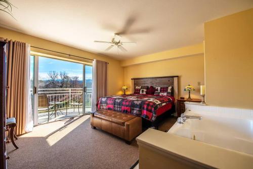 鸽子谷Amazing Mountain Views, 5 min to Dollywood&parkway的一间带一张床和一个浴缸的卧室以及一个阳台