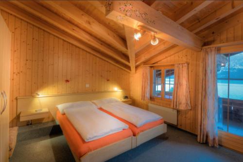 布里恩茨Hotel Wildbach Brienz的一间带床的卧室,位于带窗户的房间内