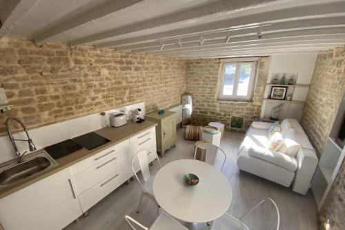 滨海吕克Charming little house with exposed stonework的厨房以及带桌子和沙发的客厅。