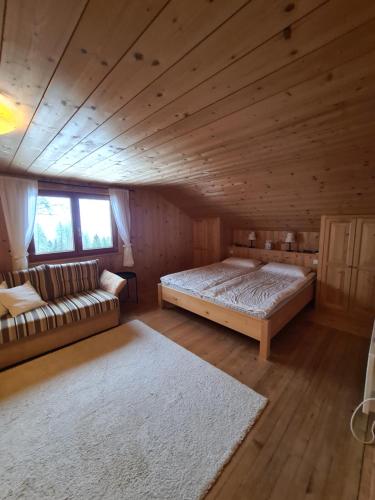 比尔塞贝格Burtscha Lodge im Sommer inklusive der Gästekarte Premium的小屋内一间卧室配有一张床和一张沙发