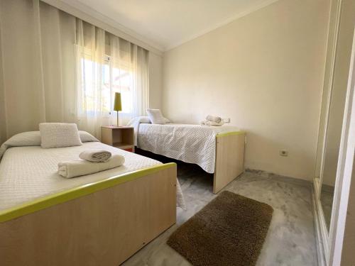 马贝拉Precioso Apartamento Puerto Banus Marbella的小房间设有两张床和窗户