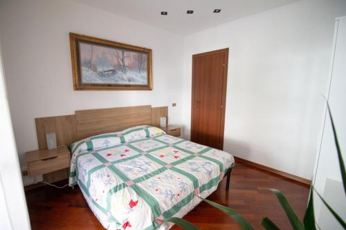 圣贝内代托-德尔特龙托Appartamento del sole的卧室配有一张床,墙上挂着一幅画