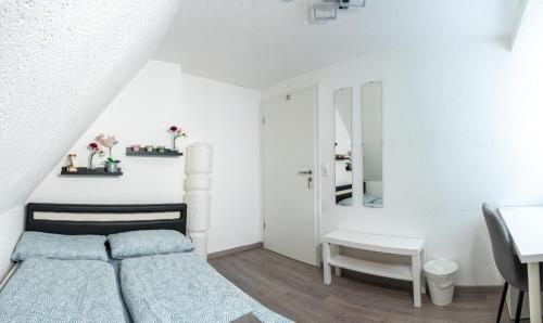 梅明根#1 modernes Zimmer mit Pool und Garten的一间白色的小卧室,配有一张床和一张书桌