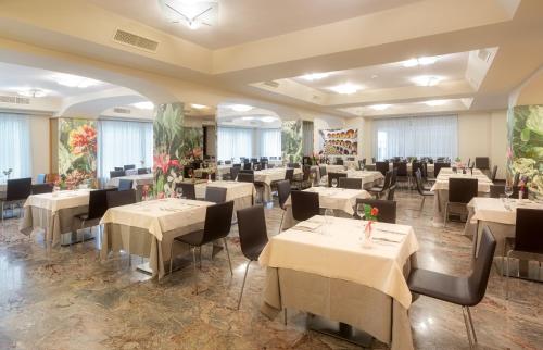 佩鲁贾珊伽洛宫殿酒店的一间设有白色桌椅的用餐室