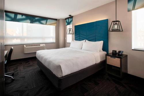 纽约曼哈顿苏豪村福朋喜来登酒店的一间卧室设有一张大床和两个窗户。