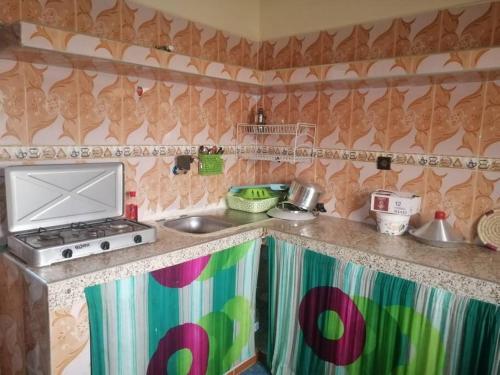 达赫拉Modern flat Dakhla的厨房配有水槽和炉灶 顶部烤箱