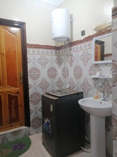 达赫拉Modern flat Dakhla的一间带水槽和黑色冰箱的浴室