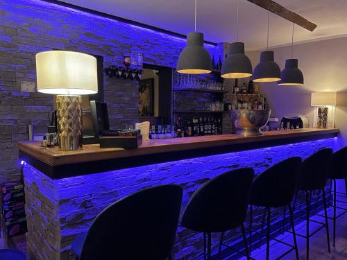 波尔蒂乔Hotel & Appartements Acqua Dolce的一间酒吧,配有黑色椅子和砖墙