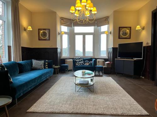 莱斯河畔的汉恩Les 3 Soeurs的客厅配有蓝色的沙发和电视