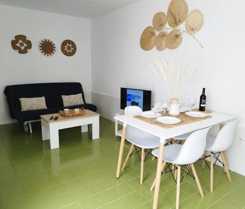 卡勒达德福斯特Charmant Appartement Casa Freesia Caleta avec piscine的客厅配有白色的桌子和白色的椅子