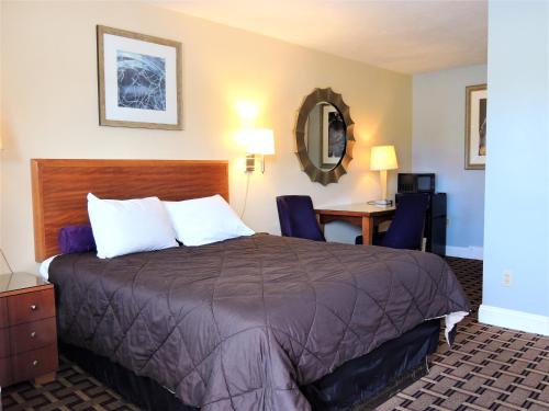 格罗顿温莎汽车旅馆的配有一张床和一张书桌的酒店客房