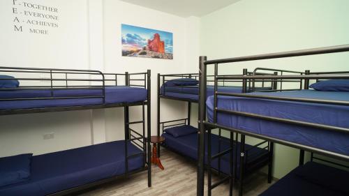 圣朱利安斯Bookarest Hostel Malta的一间设有三张双层床的客房,墙上挂着一张照片