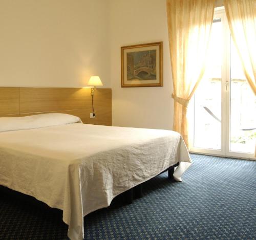托尔博莱Albergo Al Caminetto的酒店客房设有两张床和窗户。