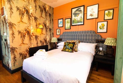 布瑞The Palm的一间卧室配有一张带橙色墙壁的大床