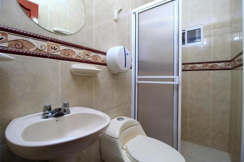 圣玛尔塔Hotel Rodadero Inn By GEH Suites的浴室配有卫生间、盥洗盆和淋浴。