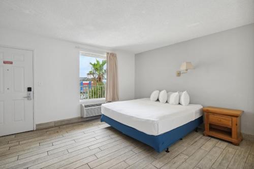 巴拿马城海滩Holiday Terrace Beachfront Hotel, a By The Sea Resort的白色的卧室设有床和窗户