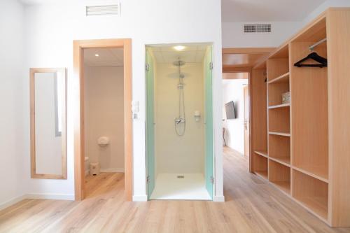 埃斯卡纳Apartamentos Playa Sol的带衣柜的客房内的步入式淋浴间