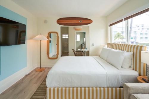 迈阿密海滩Aloha Fridays的卧室配有一张白色的大床和一张沙发。