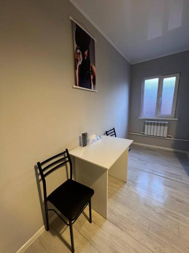 TokolʼdoshDay and Night II的客房设有一张桌子、一把椅子和一张图片