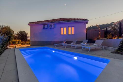 斯普利特Villa KaTess with heated pool的房子前面的蓝色游泳池