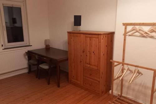 不莱梅Double Room with a Kitchen and a Shared Bathroom的客房设有木桌和木柜。