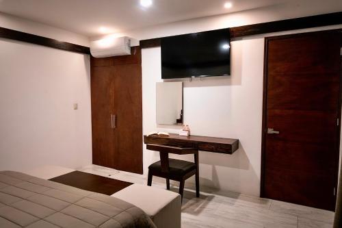 瓦哈卡市Hotel Casa Cantera的一间卧室配有一张桌子和一台墙上的电视。