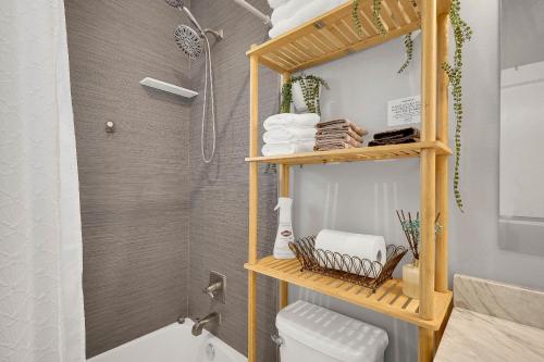 西棕榈滩Wellington Garden的带淋浴、卫生间和毛巾的浴室