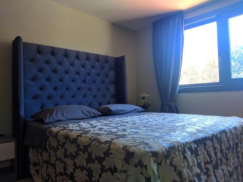PandokrátorLANDR House的一间卧室配有一张大床和蓝色床头板