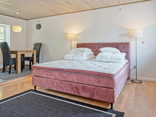 伦讷Holiday home Rønne VI的一张大床,位于带桌椅的房间