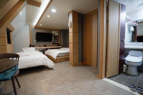 木浦市Mokpo Well hotel的酒店客房设有两张床和卫生间。