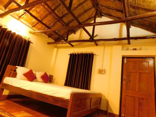 加尔各答Gram Bangla Retreat的一间卧室配有一张木床和木门