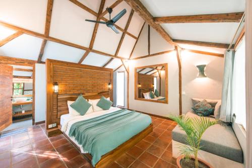 吉利特拉旺安椰子花园度假酒店的一间卧室配有一张大床和镜子