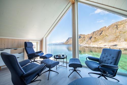 巴尔斯塔Lofoten Waterfront luxury lodge的客房设有带椅子和桌子的大窗户。