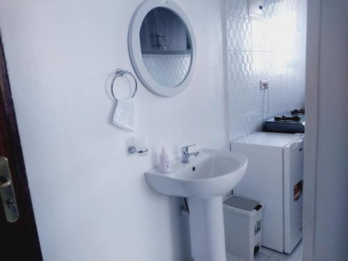 蒙巴萨C.leslie_homes的白色的浴室设有水槽和镜子