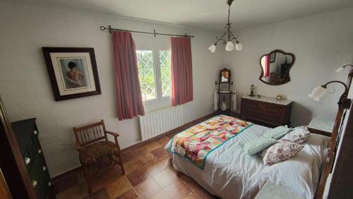 贝塞里尔德拉谢拉El huerto de la Reina的卧室配有床、椅子和窗户。