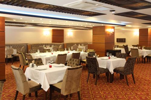 萨卡里亚萨卡里亚阿里亚酒店的一间设有白色桌椅的用餐室
