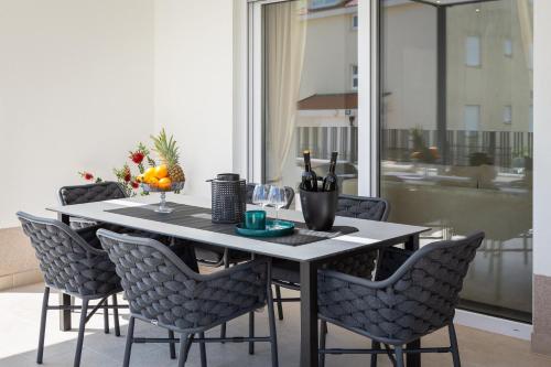 普罗马尼亚A&D Deluxe apartments Dani with swimming pool的餐桌、椅子和桌子及酒杯