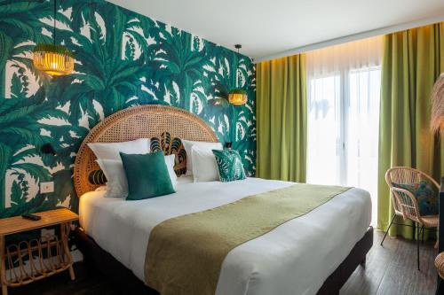 勒拉旺杜Hôtel La Piscine的一间卧室设有一张大床和绿色的墙壁